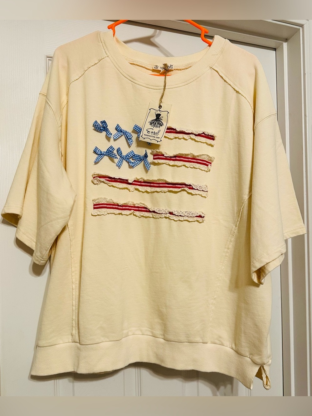 easel Cream Short-Sleeve Crewneck Shirt with Blue Bow & Red Ribbon Accents
